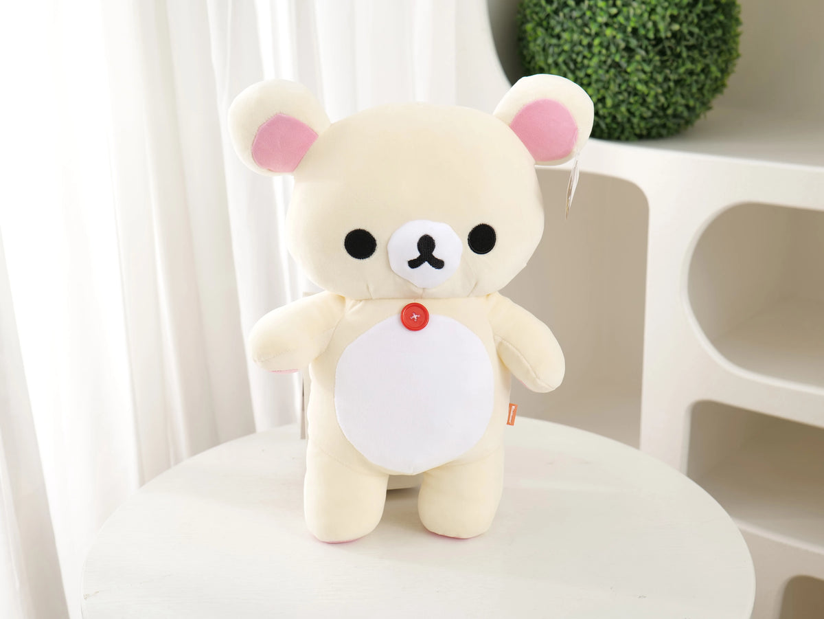 A cute white and pink Rilakkuma strawberry bear plush toy sitting on a white surface.