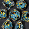 A collection of handmade liquid core resin dice set with sharp edges, featuring various numbers and symbols in blue glitter.