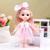A pink articulated princess doll with a sparkly dress and bow, standing on a white surface.