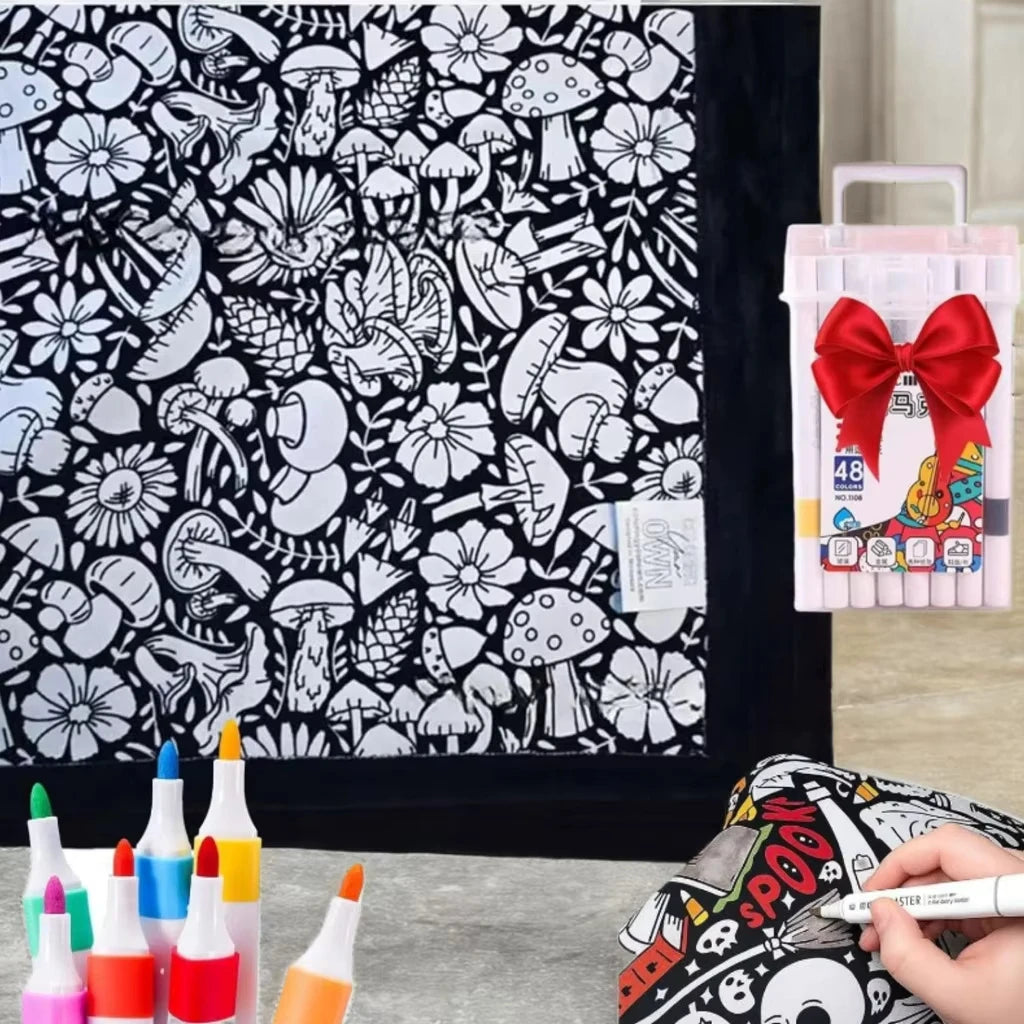 A DIY coloring blanket with 24 markers and a washable velvet throw is displayed next to some art supplies.