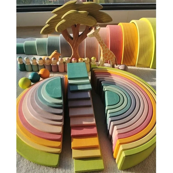 Un set colorido de bloques de madera apilables dispuestos en un arcoíris sobre una superficie clara.