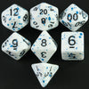 A collection of white acrylic dice showing various numbers and dots on a black surface.