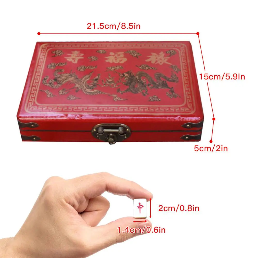 A red carrying case for a classic Chinese Mahjong set, shown next to a hand for scale.