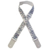 A beige woven guitar strap with blue floral embroidery and leather accents, shown crossed.