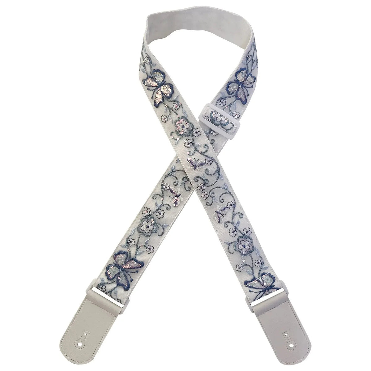 A beige woven guitar strap with blue floral embroidery and leather accents, shown crossed.