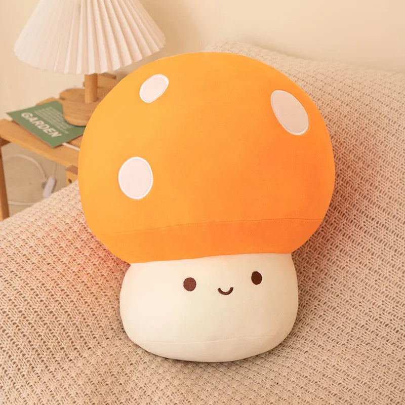 An orange and white mushroom plush pillow with round spots resting on a beige textured surface.