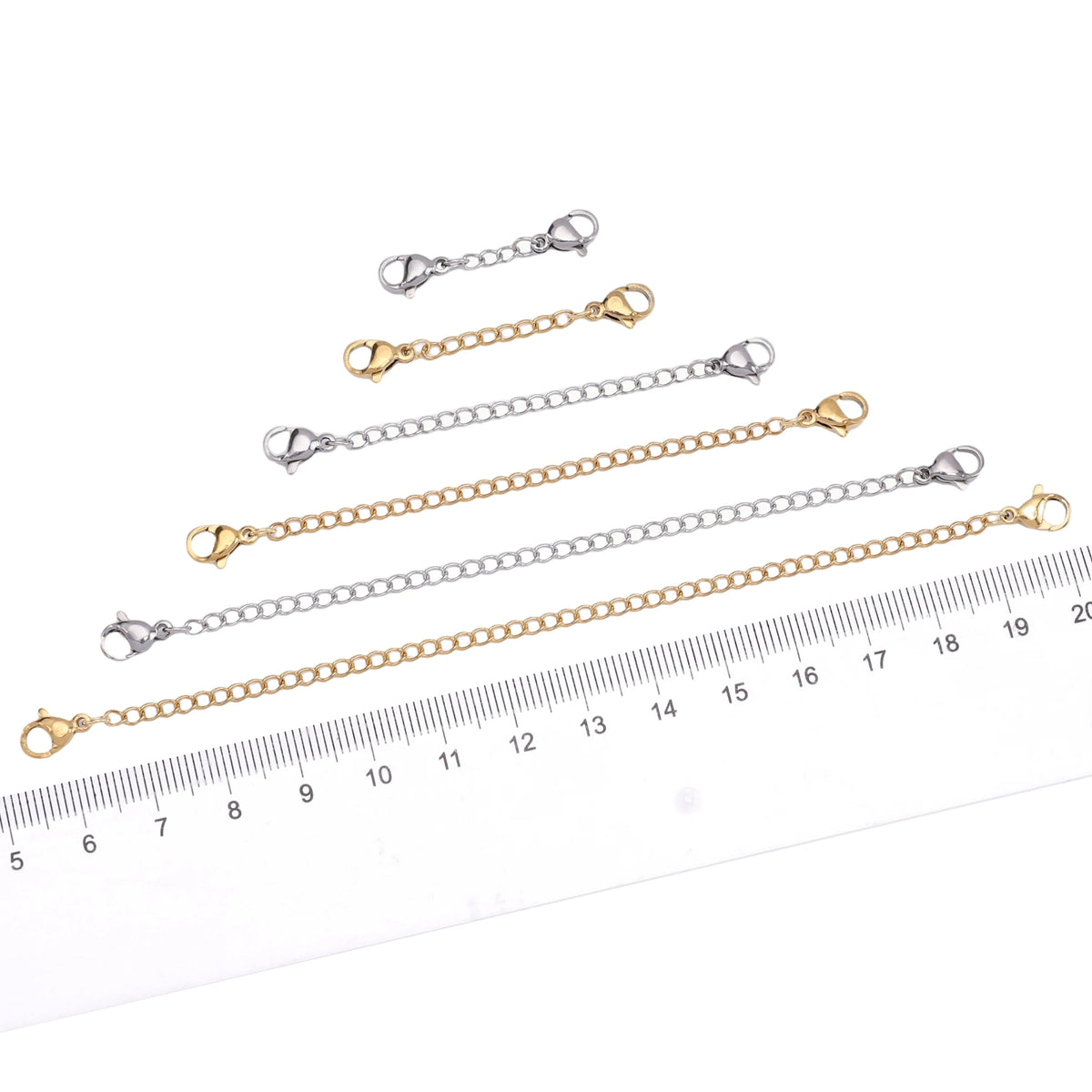 Multiple stainless steel extension chains with lobster clasps shown against a ruler for size reference