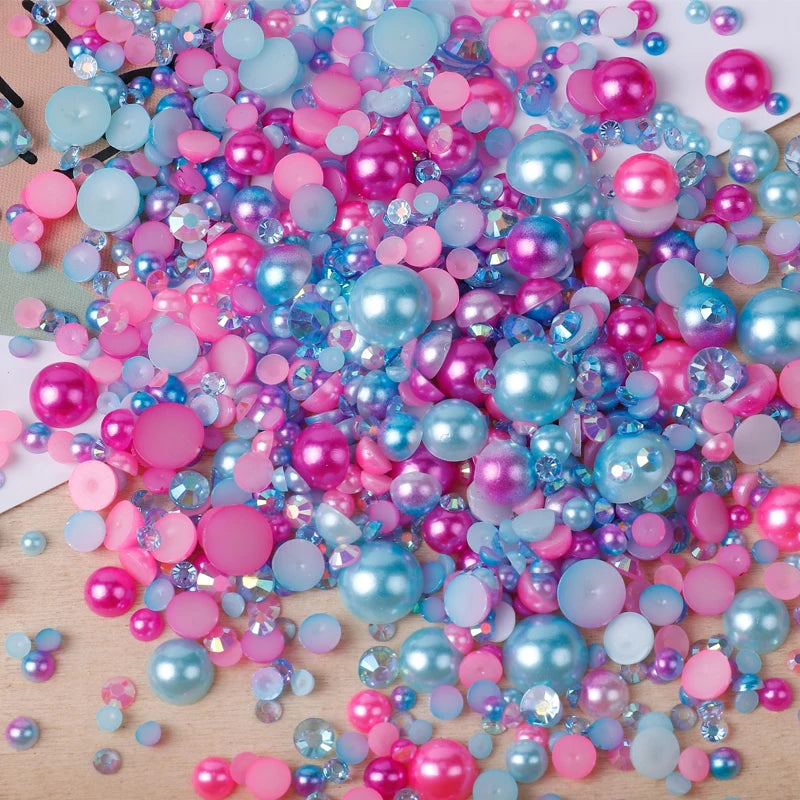 A pile of mixed resin rhinestone pearls in various shades of pink, blue, and purple with an AB finish for crafts and nail art