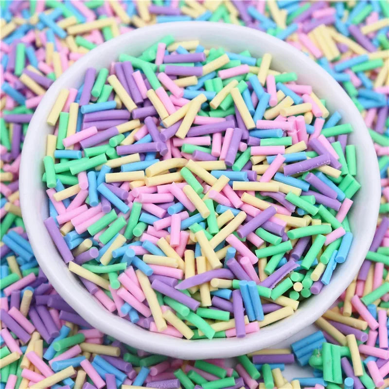 A bowl filled with colorful polymer clay slice sprinkles in various shades of pink, green, and yellow for slime and DIY craft