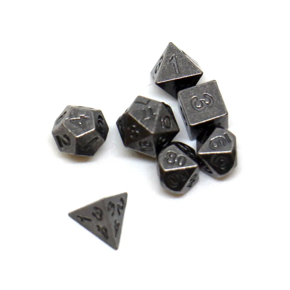 A set of seven antique metal polyhedral dice, including a d4, d6, d8, d10, d12, d20, and d100.
