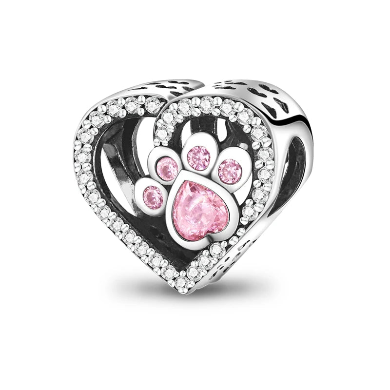 A heart-shaped sterling silver charm bead featuring a paw print design and pink zircon stones.