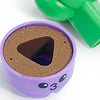 A purple sorting toy with a brown cylinder and a green handle is shown.