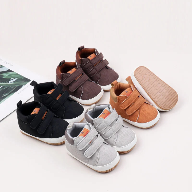 A collection of soft PU leather baby first walker shoes in brown, black, and tan colors with anti-slip soles.