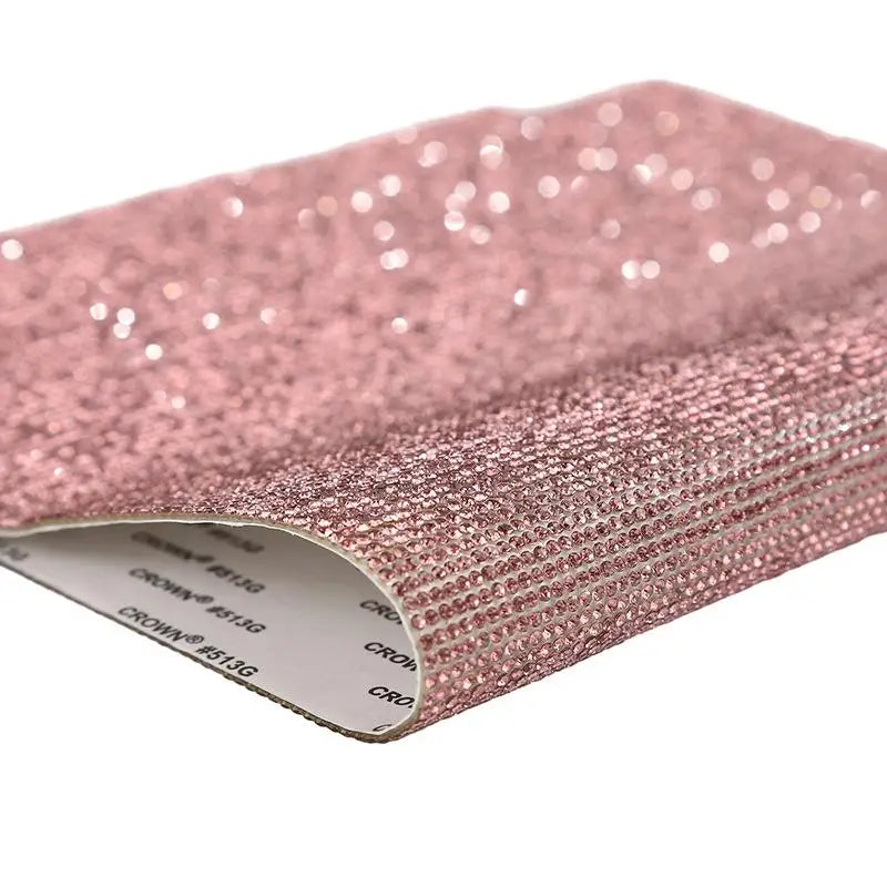 Pink sparkling rhinestone adhesive tape rolled up for DIY crafts and decor