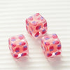 Two pink floral square resin beads with a translucent finish are displayed on a white background.