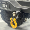 Close-up of a black metal trailer hitch receiver TRX-4 for an RC crawler car, showing the yellow mounting bracket.