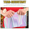Hands are tearing holographic rainbow sticker paper for inkjet printers.