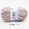 A ball of multi-colored yarn featuring pink, green, and white threads labeled as Jane cotton yarn.