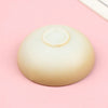 A smooth, beige miniature dollhouse rice bowl is shown against a light pink background.