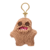 A fluffy brown plush monster keychain with large eyes and a smiling mouth.
