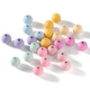 A collection of matte acrylic round beads in various pastel colors including blue, yellow, pink, and green.