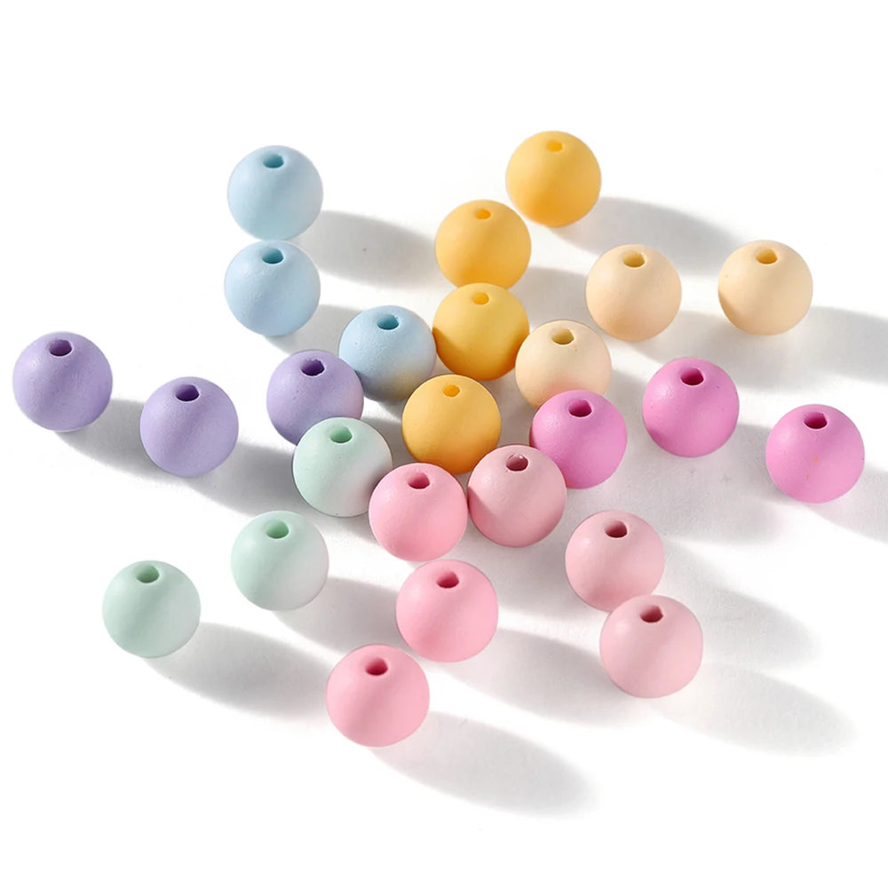 A collection of matte acrylic round beads in various pastel colors including blue, yellow, pink, and green.