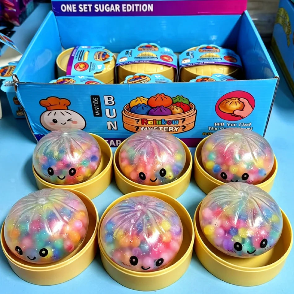 A set of glitter dumpling squishy stress relief toys in yellow packaging and display boxes.