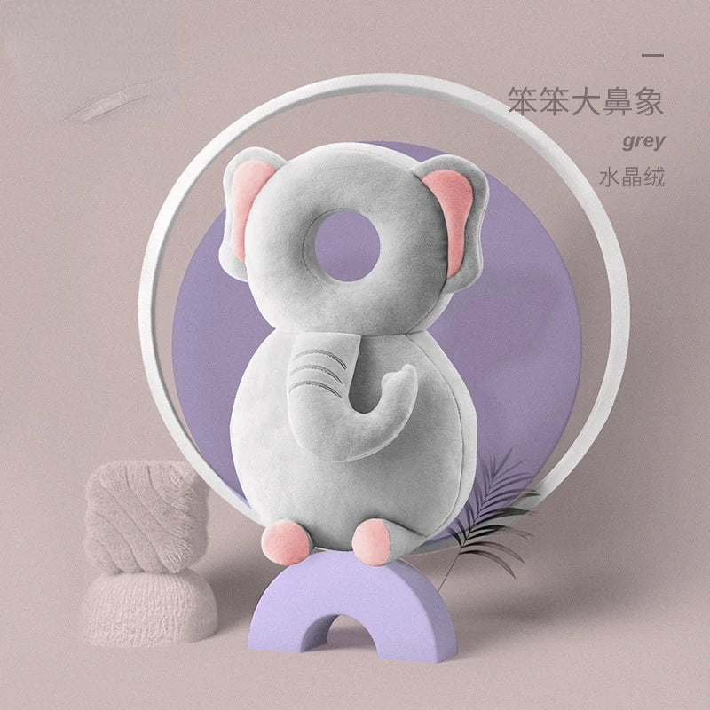 A grey elephant plush toy sitting on a purple base, with a knitted ball nearby.