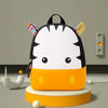 A cute, orange and white striped 3D animal kids backpack with black accents sitting on a round platform.