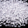 A pile of clear, sparkling crystal flatback rhinestones for nail art and crafts.