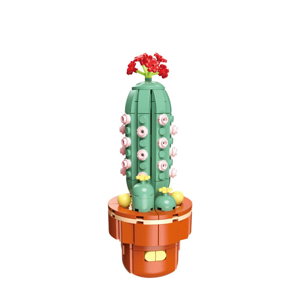 A green cactus building block with pink flowers on top, sitting in an orange base.