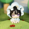 A white blind box figure with dark hair and purple eyes wearing a ruffled hood, sitting on green moss.