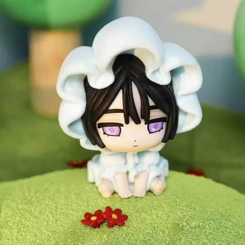 A white blind box figure with dark hair and purple eyes wearing a ruffled hood, sitting on green moss.