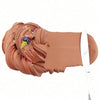 A tube of brown butter slime with colorful cake decorations is being scooped out by a silver spatula.
