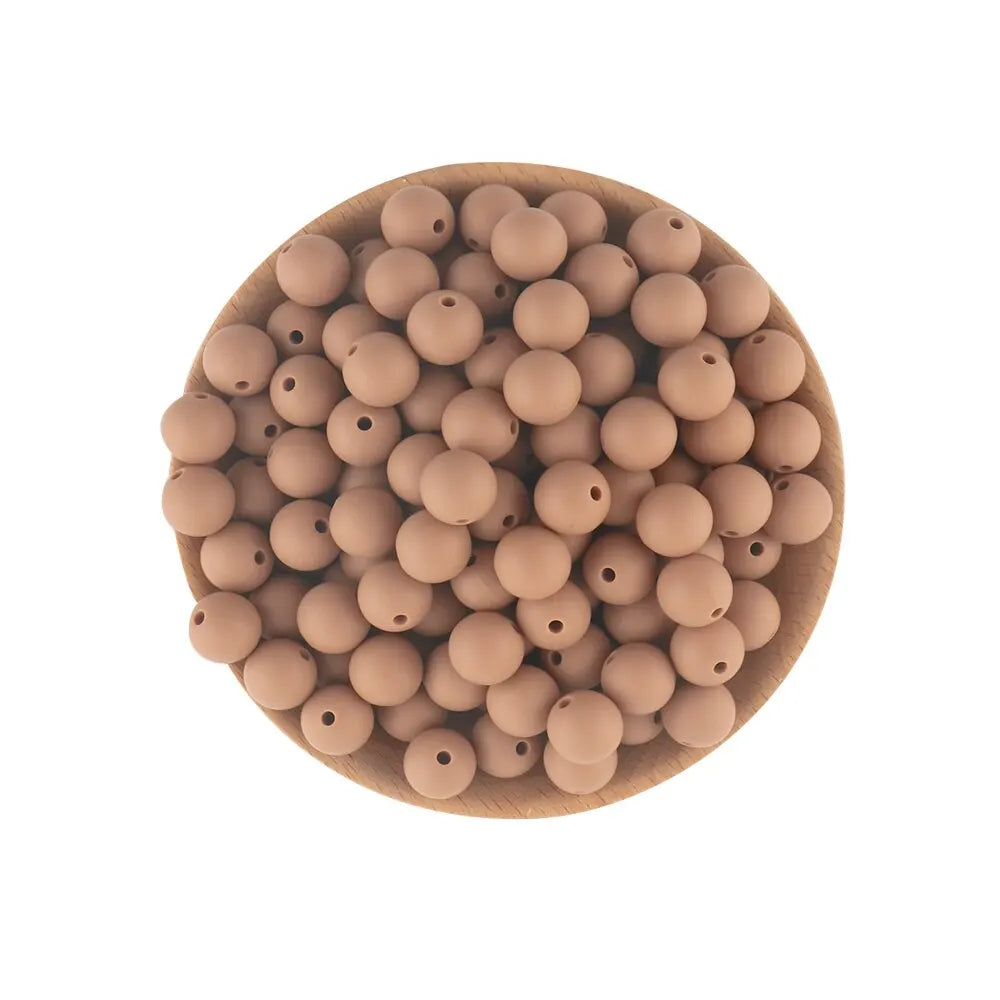 A wooden bowl filled with small, round, light brown silicone beads for jewelry making and crafts.