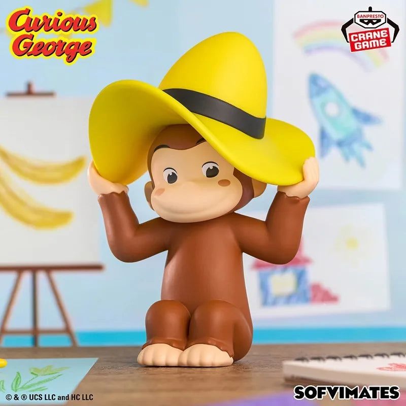 A collectible figure of Curious George in a yellow hat sitting on a wooden surface.
