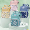 A collection of pink, yellow, and blue mommy backpacks with wet/dry separation features displayed on tiered white pedestals.