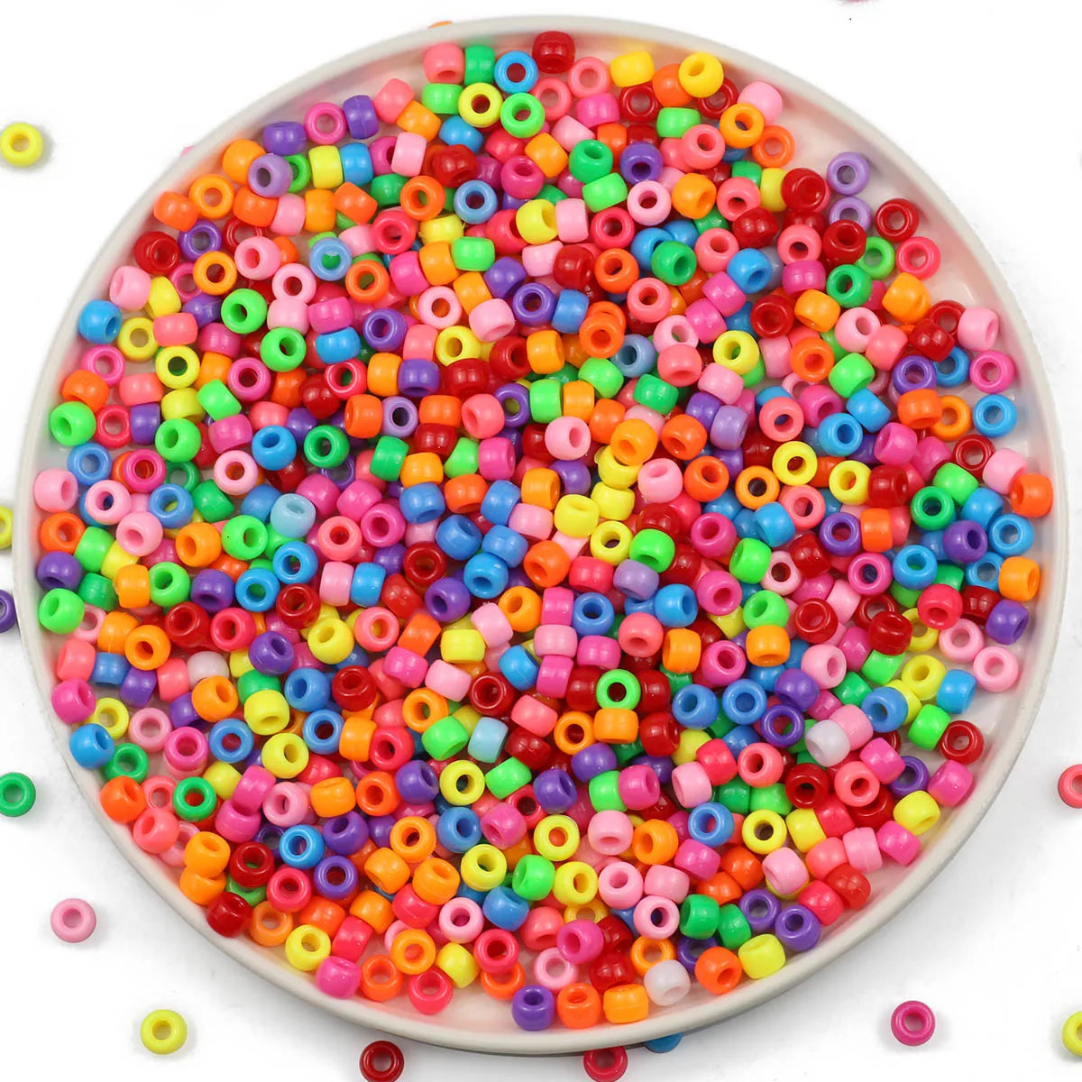 A bowl filled with a large assortment of colorful pony beads for jewelry making and crafts