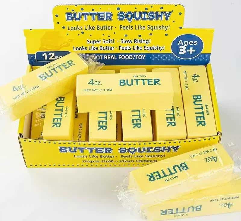 A box of Butter Squishy toys in yellow packaging with butter-shaped blocks.