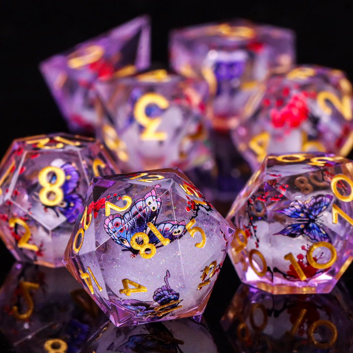 A close-up of a set of iridescent plum blossom liquid core resin dice reflecting on a dark surface.