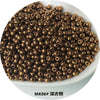 A pile of small, round, gold-colored metallic glass beads for jewelry and crafting.