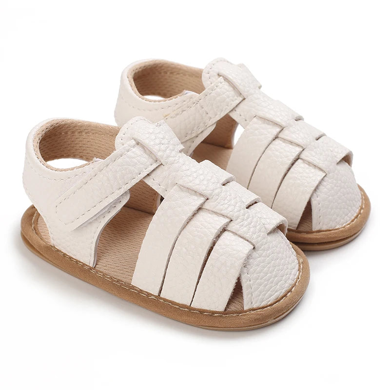 A pair of light beige breathable baby first walker sandals with a woven strap design and soft anti-slip sole.