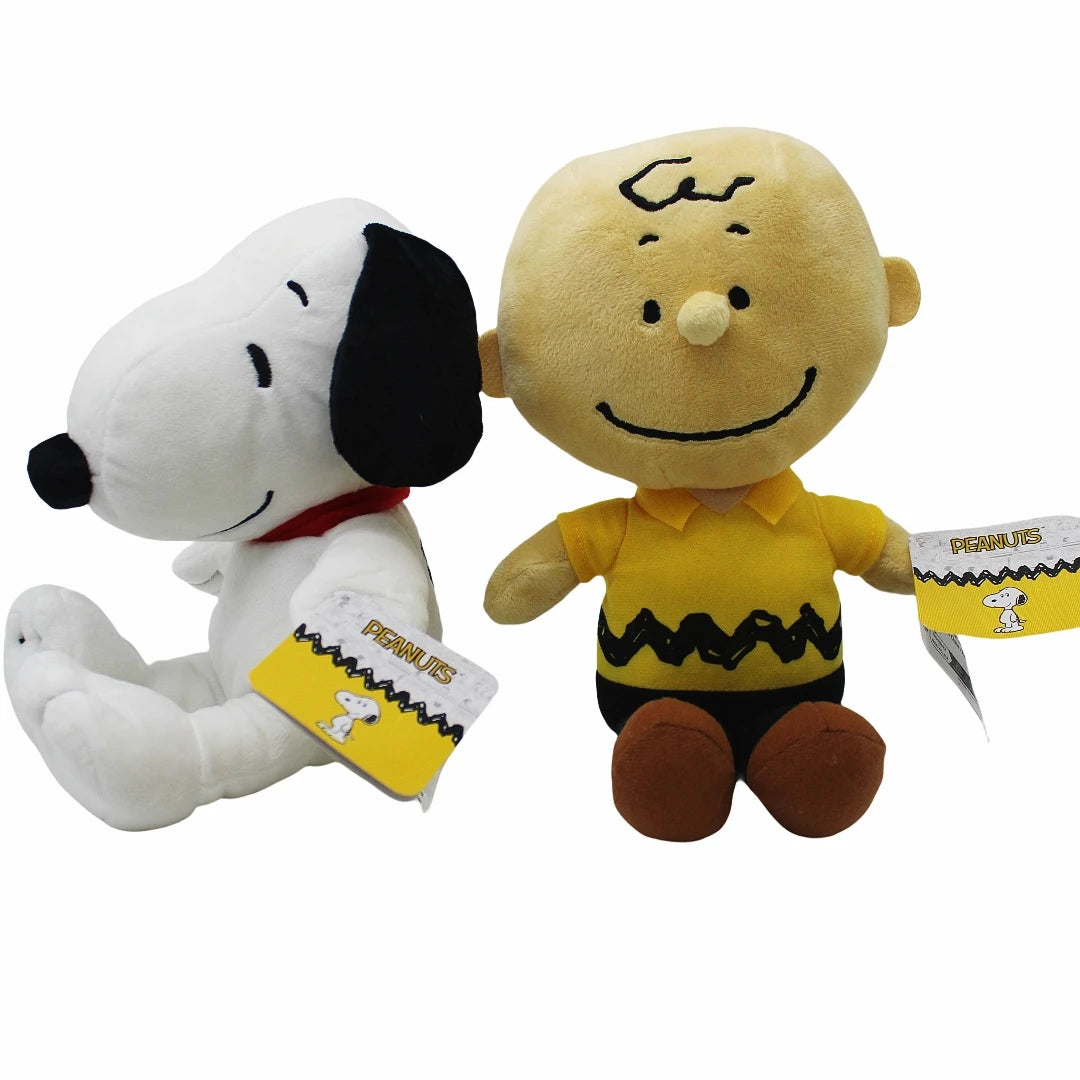 A soft plush toy of Snoopy with a yellow shirt and brown legs, accompanied by a yellow tag.