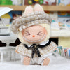 A cute doll wearing a beige tweed beret and matching cape set.
