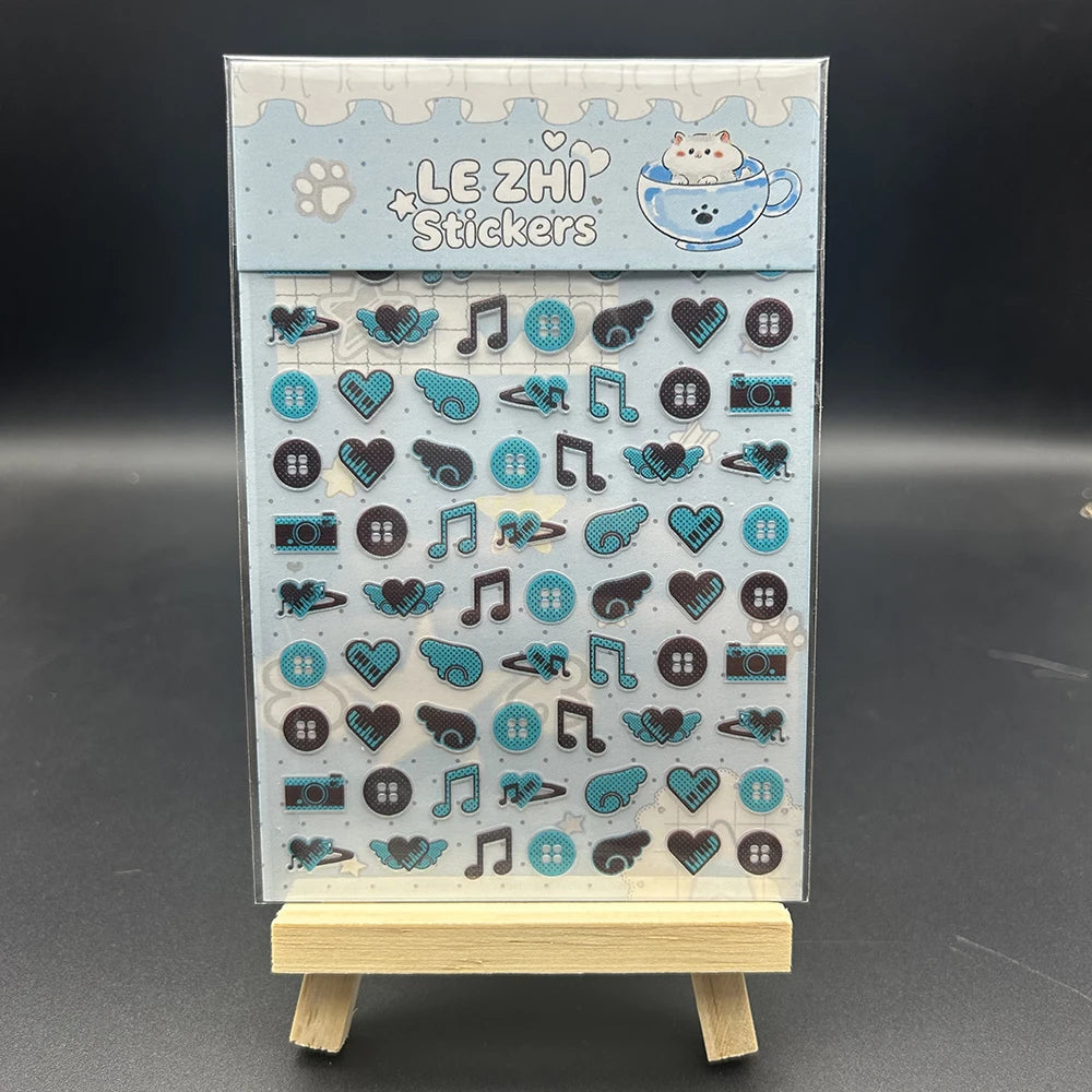 A vertical display of decorative stickers featuring cats, musical notes, hearts, and various icons for crafting.
