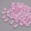 A pile of pink, translucent glass beads shaped like tulip flowers.