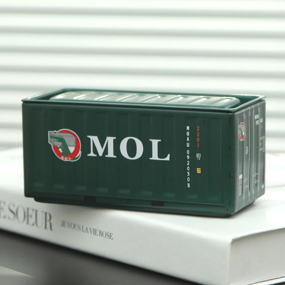 A dark green industrial iron storage box with the MOL logo resting on a white surface.
