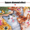 A close-up of a diamond painting featuring cats and flowers in warm orange, pink, and white tones.