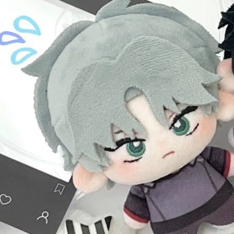 A plush keychain set featuring a light gray character with green eyes and dark clothing.