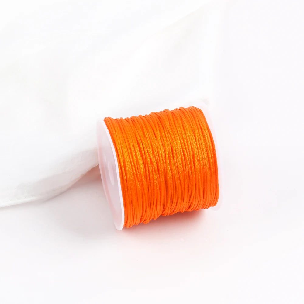 A roll of bright orange 0.8mm cotton nylon macrame cord for jewelry making and crafts.